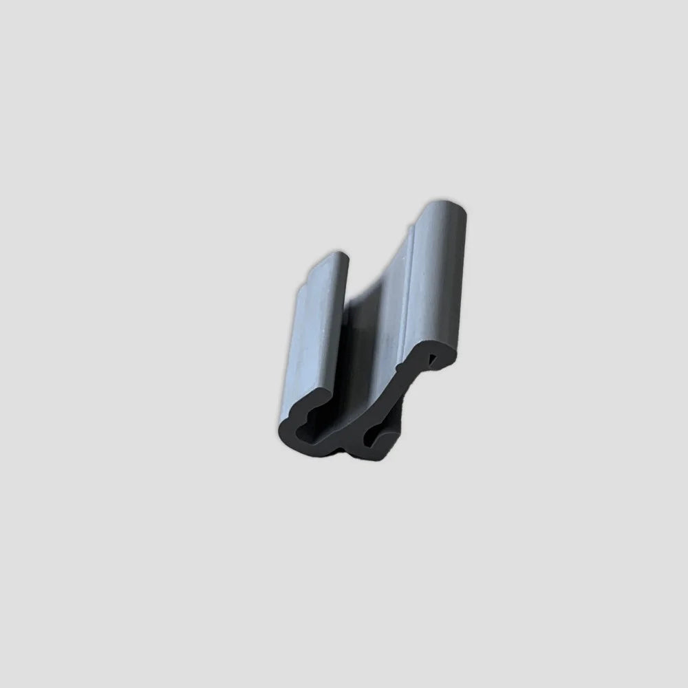 Gray, U-shaped plastic clip rests against a neutral gray background, appearing stationary and elevated, likely used for securing panels or similar materials in Rhino Greenhouse construction.