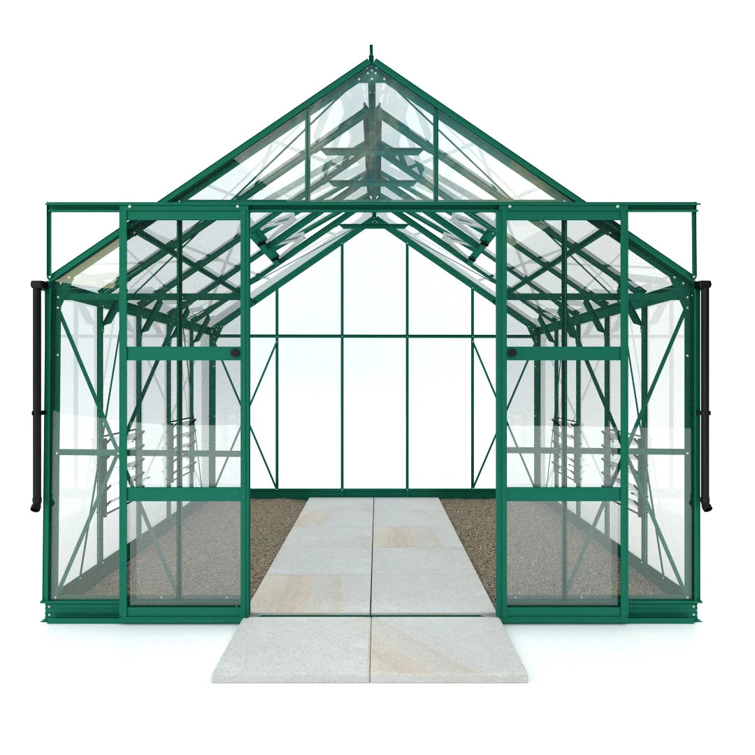 A green metal-framed Rhino Greenhouse with glass panels stands on a stone path. The structure features sliding doors and an A-frame roof, providing a spacious interior for gardening activities.