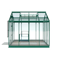 A green metal-framed Rhino Greenhouse with transparent glass panels sits empty, featuring a sliding door and roof vents. It is positioned on a slatted stone base, indoors.