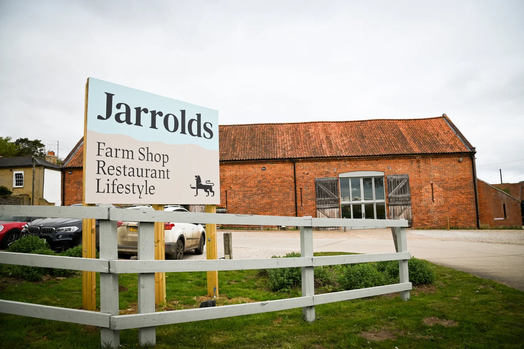 A Jarrolds Letheringsett farm shop sign in front of a converted barn