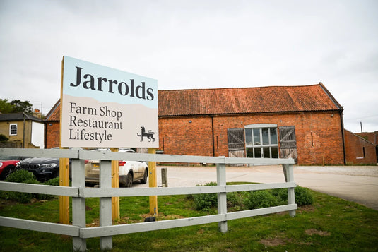 A Jarrolds Letheringsett farm shop sign in front of a converted barn