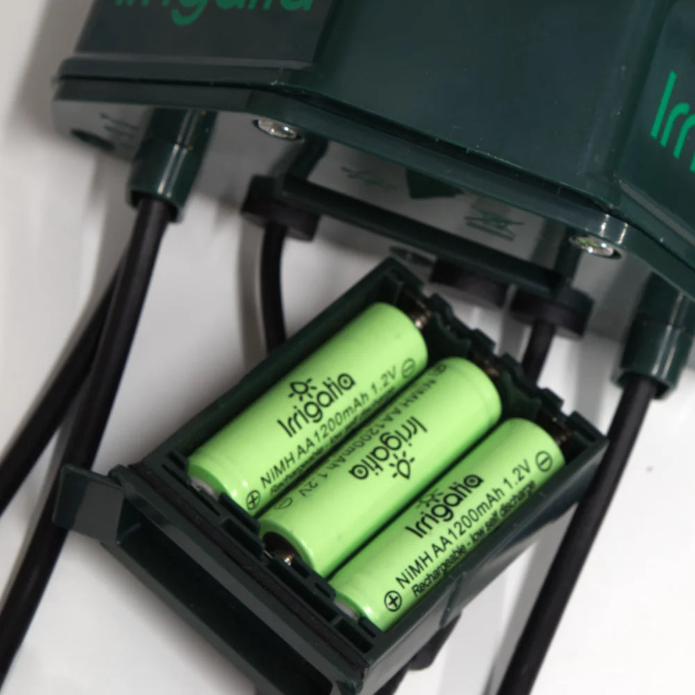 Battery compartment containing three green AA 1200mAh NiMH batteries labeled Irrigatia, connected by black wires; device above marked Irri*.