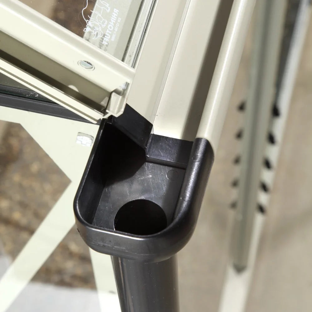 A Rhino Greenhouse gutter end cap with a drainage outlet is positioned at the corner of an aluminum frame. It's part of a structure that collects and directs rainwater. Text: RHINO AUTOVENT.