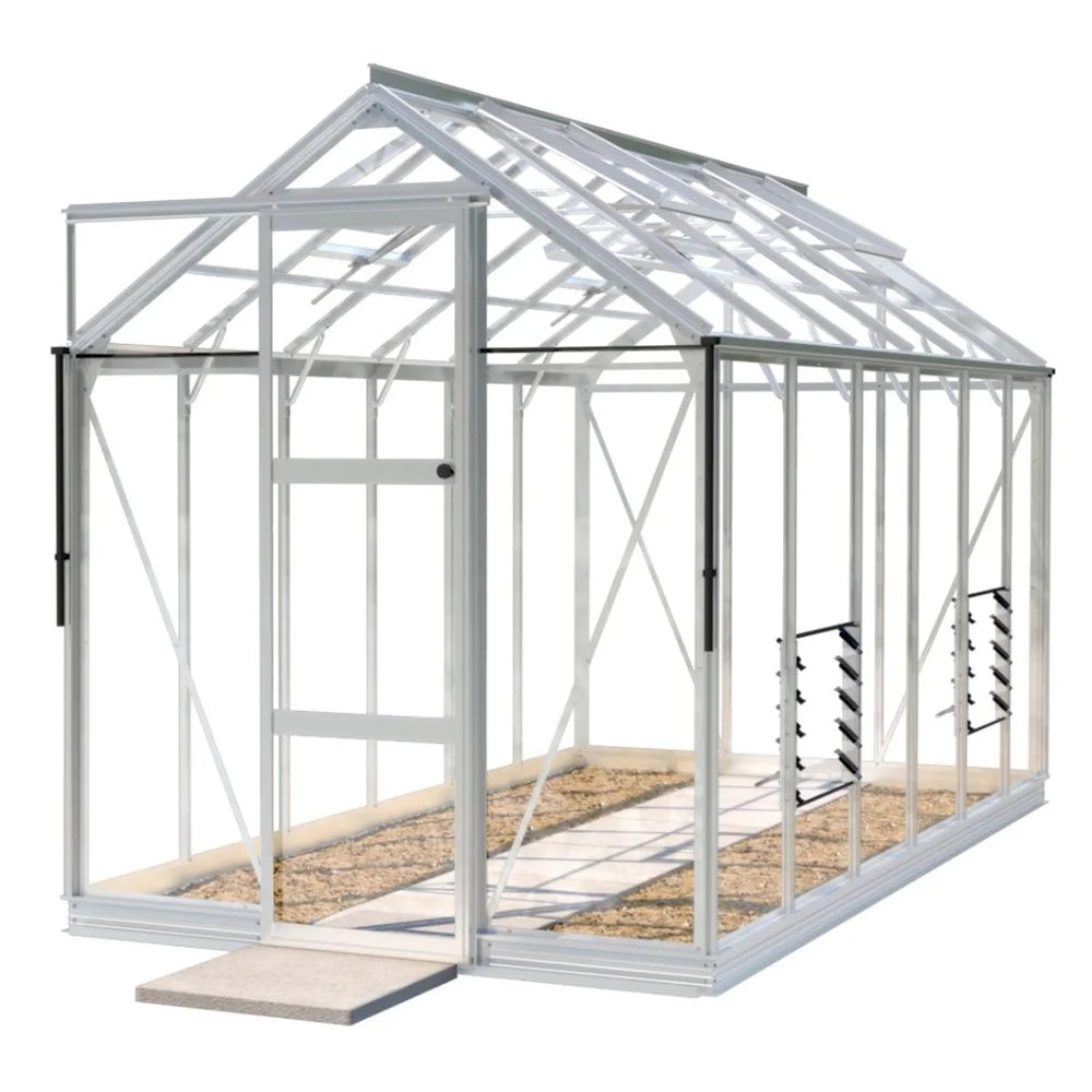 A small, transparent Rhino Greenhouse with a metal frame stands empty on concrete, featuring a sliding door and an interior with a gravel path, set against a plain white background.