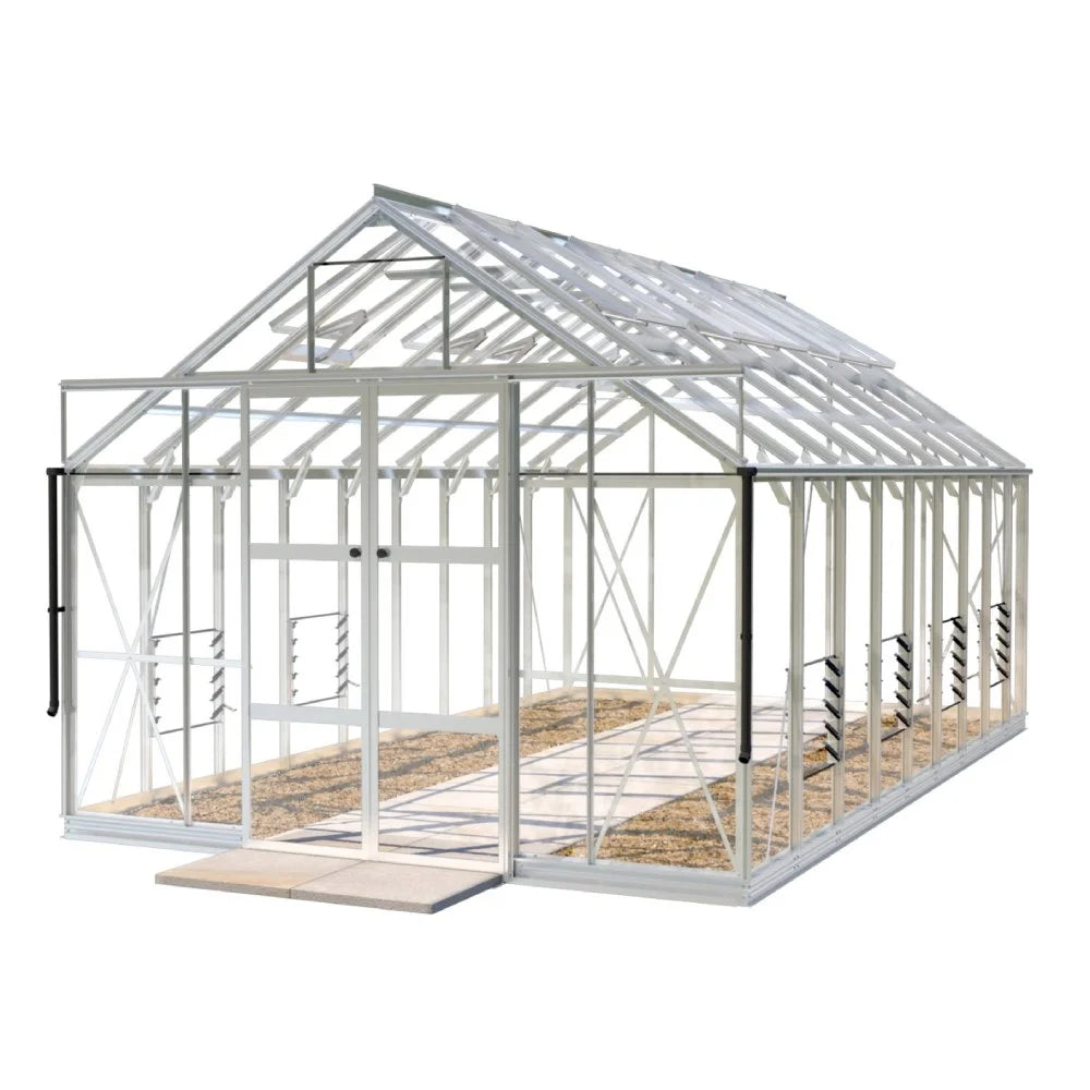 A large, white-framed Rhino Greenhouse stands empty, showcasing its glass panels and gabled roof. It sits on a gravel path and appears ready for gardening activities in a bright, clear setting.