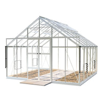 A white-framed Rhino Greenhouse stands with open doors, revealing an empty interior on a stone surface. It features transparent panels and appears ready for gardening within a spacious environment.