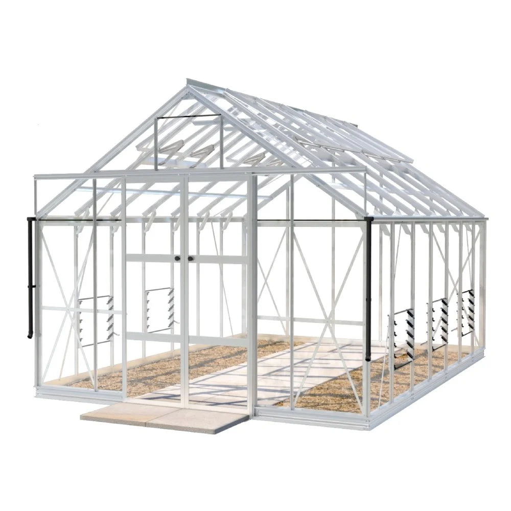 A glass Rhino Greenhouse with a white frame sits on a concrete slab, featuring sliding doors and roof vents. The interior shows a gravel pathway, and the structure is spacious.