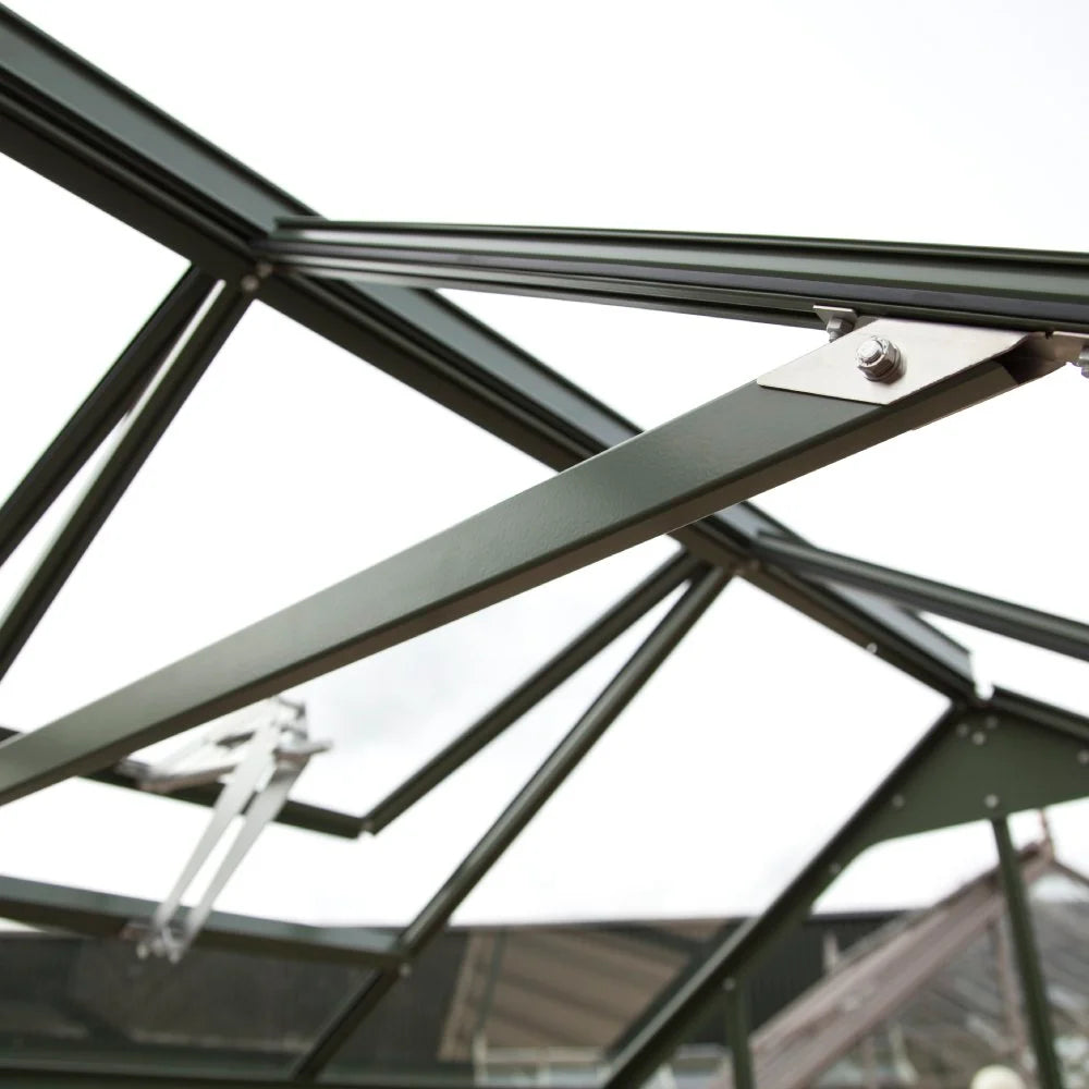 Metal Rhino Greenhouse frame with bolted joints, viewed from inside. It reveals a bright sky, suggesting an outdoor setting. The structure appears sturdy and well-designed, typical of Rhino Rhino Greenhouses.