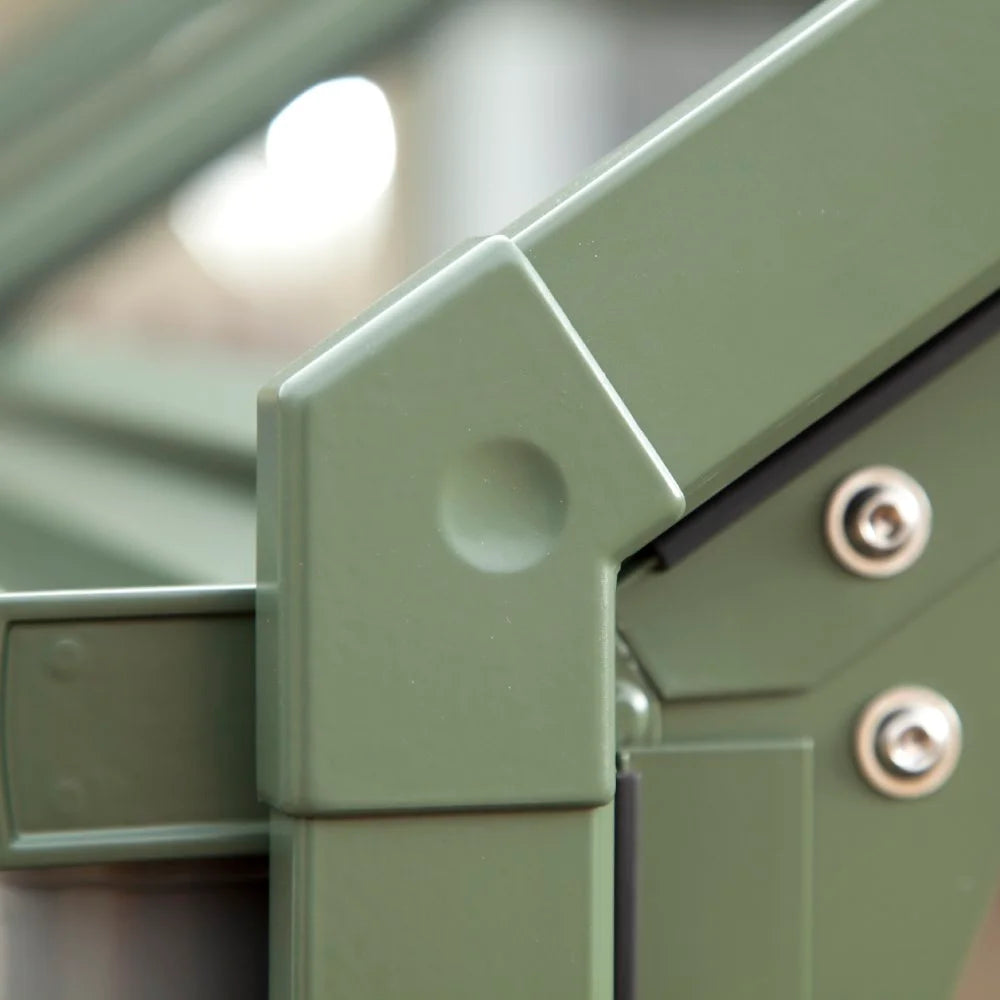 Green metal frame corners are securely fastened with screws, forming part of a Rhino Greenhouse structure; the background is softly blurred, emphasizing the construction detail.